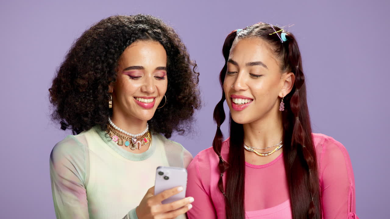 Due donne sorridenti che guardano un cellulare