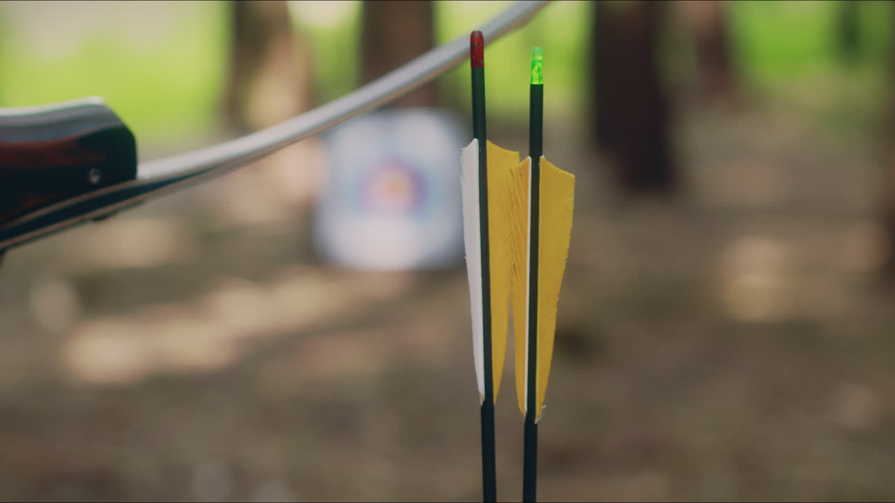 chica de tiro con arco escoge una flecha desde el suelo tiro de cerca