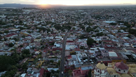 drone crossing peacefully over one of the main avenues over san miguel de allende mexico