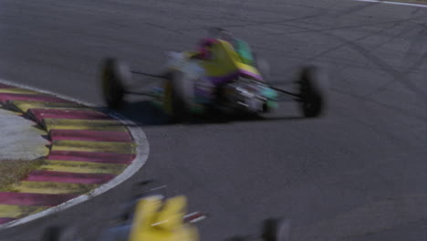 two race cars speed around a turn on a race track