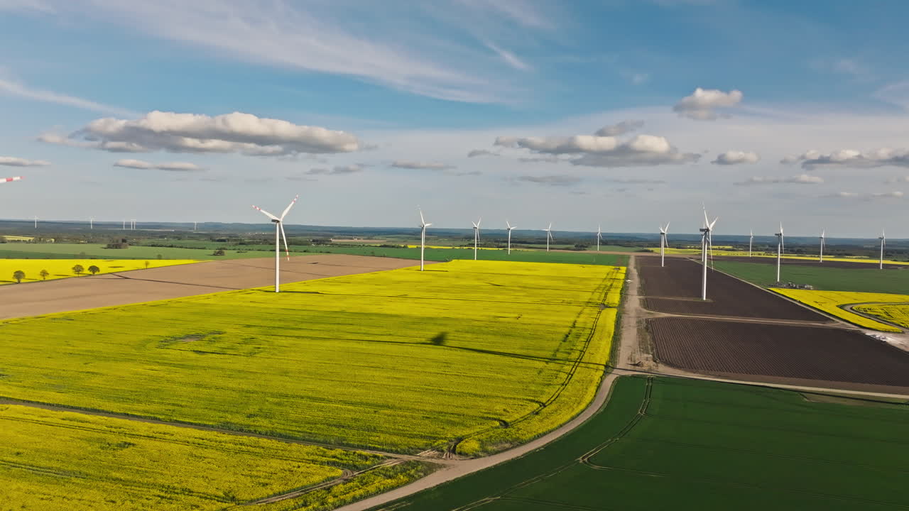 Push in drone shot of wind turbines in a wind farm during the day, renewable energy