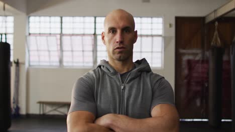 portrait of fit caucasian man with arms crossed at the gym