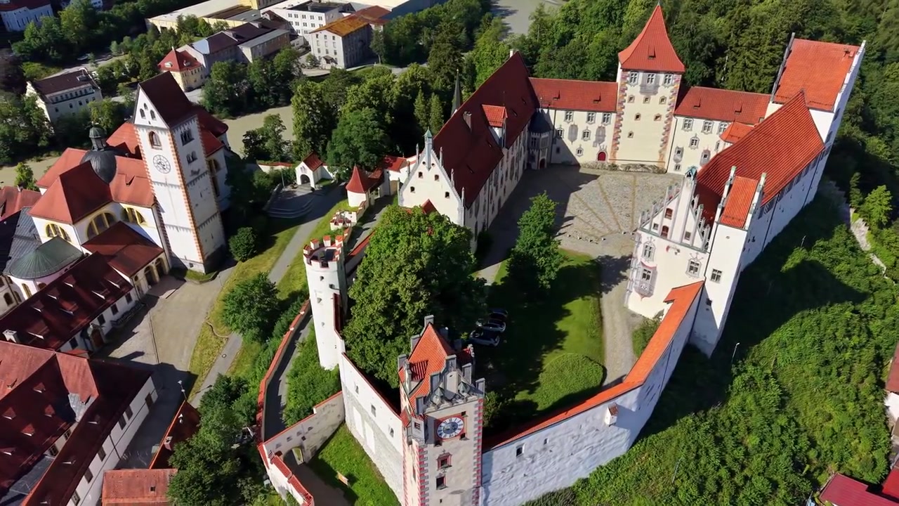 Vista aerea con drone delle mura bianche e delle finestre dipinte del castello Hohes Schloss sopra il centro storico, Füssen, Germania