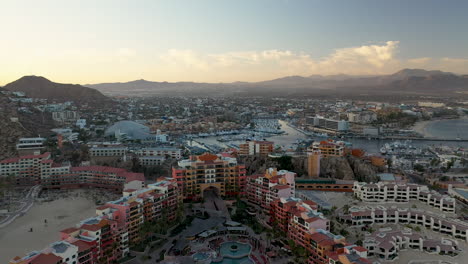 tiro de drone de resorts en playa el médano con montañas en la distancia en cabo san lucas mexico, ancho y giratorio