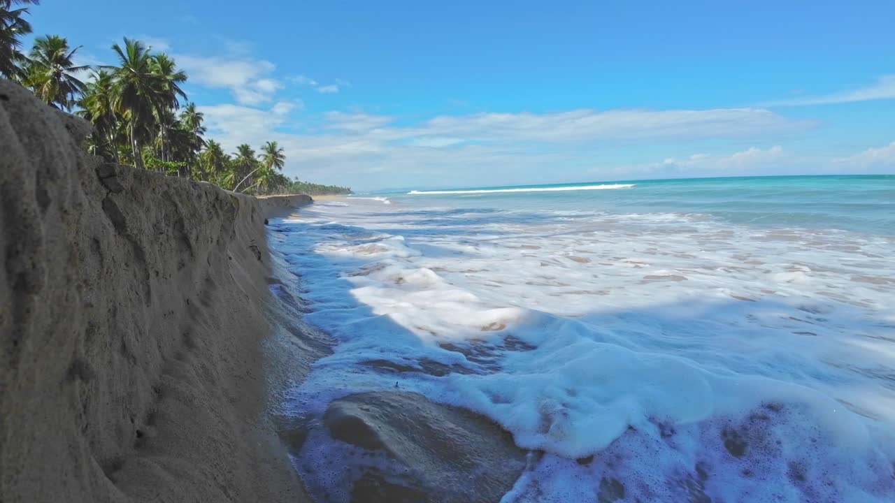 Olas espumosas del mar bañando la playa de arena en Playa Cosón, Las Terrenas, República Dominicana - cámara lenta