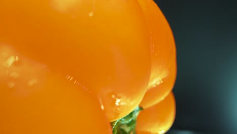 A-vertical-crispy-macro-close-up-shot-of-a-wet-sweet-yellow-pepper-on-a-360-rotating-stand,-shiny-sweaty-water-drops,-cinematic-studio-lighting,-slow-motion,-4k-video