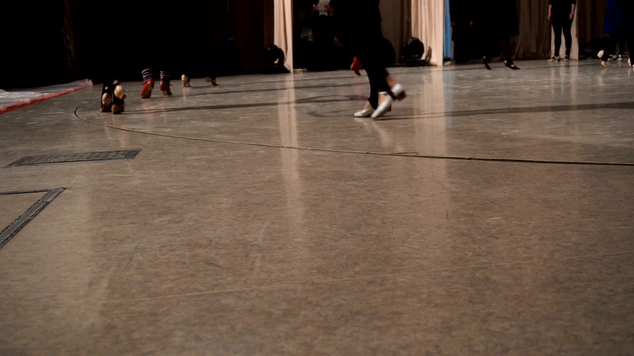 무대 위에 줄지어 춤추는 여성 발의 클로즈업입니다.