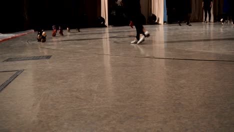 un primer plano de las mujeres alineadas bailando los pies en el escenario.