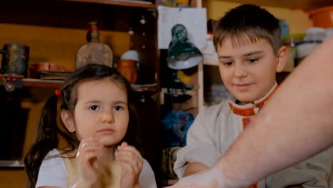 potter showing how to work with ceramic in pottery studio