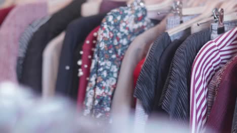 panning movement of second hand clothing hanging in a thrift shop