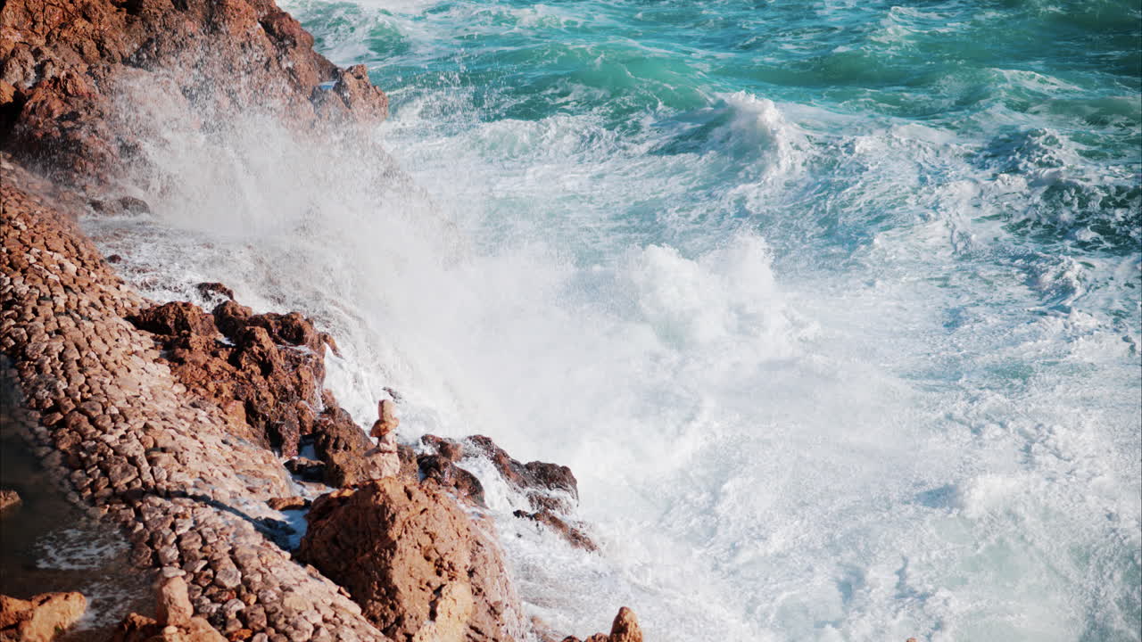 Waves hitting the rocks on the shore and splashing