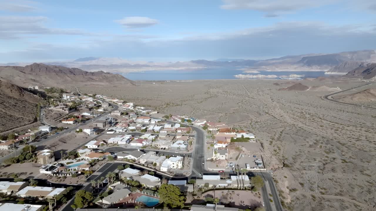 vecindario en boulder city, nevada con el lago mead en la distancia y el video del dron que se mueve hacia abajo