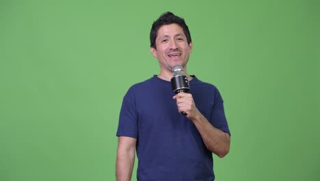 hispanic man presenting something with microphone