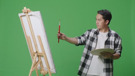 man painting on easel