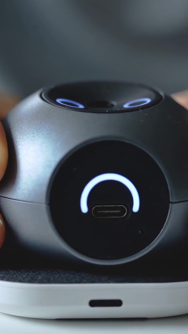 Video verticale: Mano che muove un dispositivo, il dispositivo illumina un arco sopra una base bianca per la ricarica tramite USB-C.