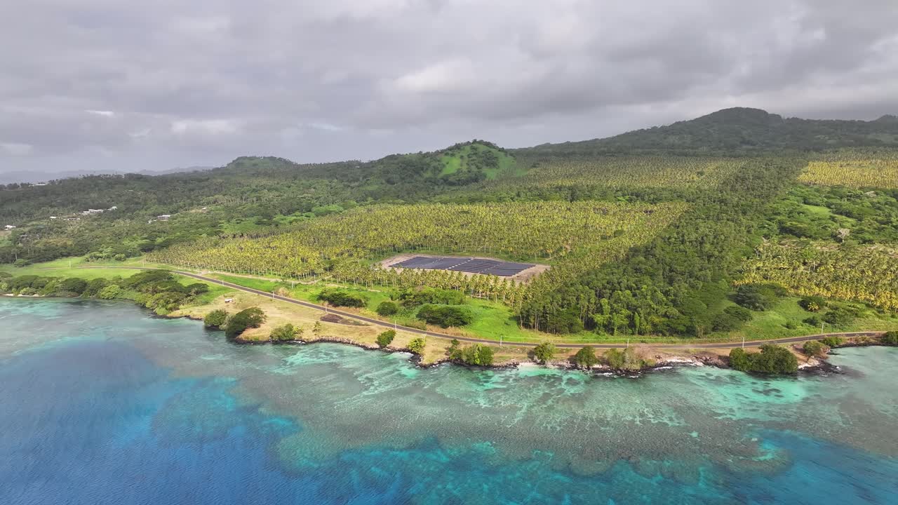 Tropical scenery of taveuni Island in Fiji, with scenic road by the shore, power plant and mountains.