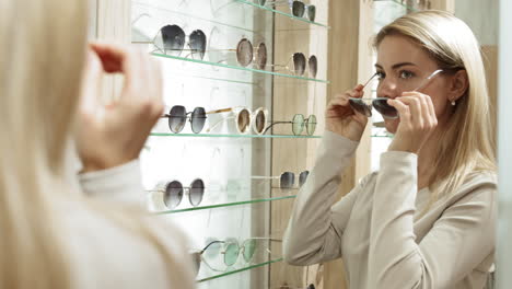 woman trying on sunglasses in an optical store