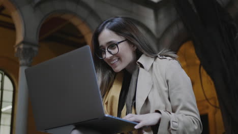 student reading on laptop screen at college