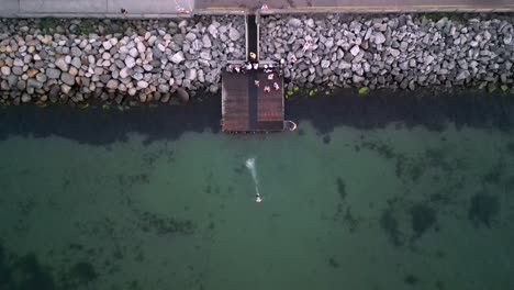 nadadores saltando desde el dron del muelle