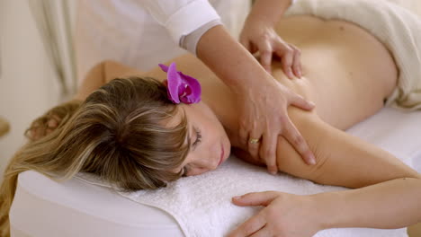 una mujer recibiendo un masaje de espalda en un spa.
