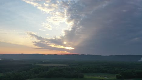 sunrise over a valley with clouds and hills