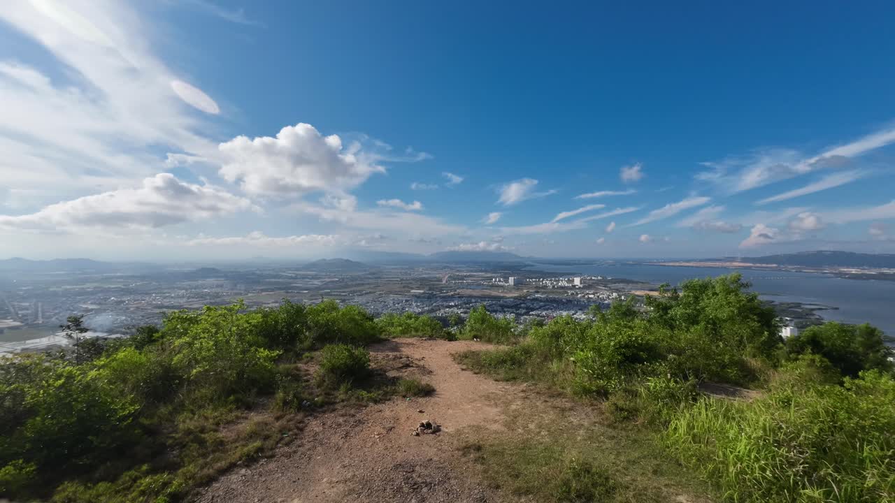 Dynamic timelapse footage showing panoramic view of Quy Nhon city and coastline from Ba Hoa mountain peak in Binh Dinh Vietnam with moving clouds and shifting light