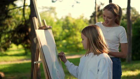 girl painting outdoors with a tutor