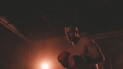 shirtless boxer man warms up by punching the air 1