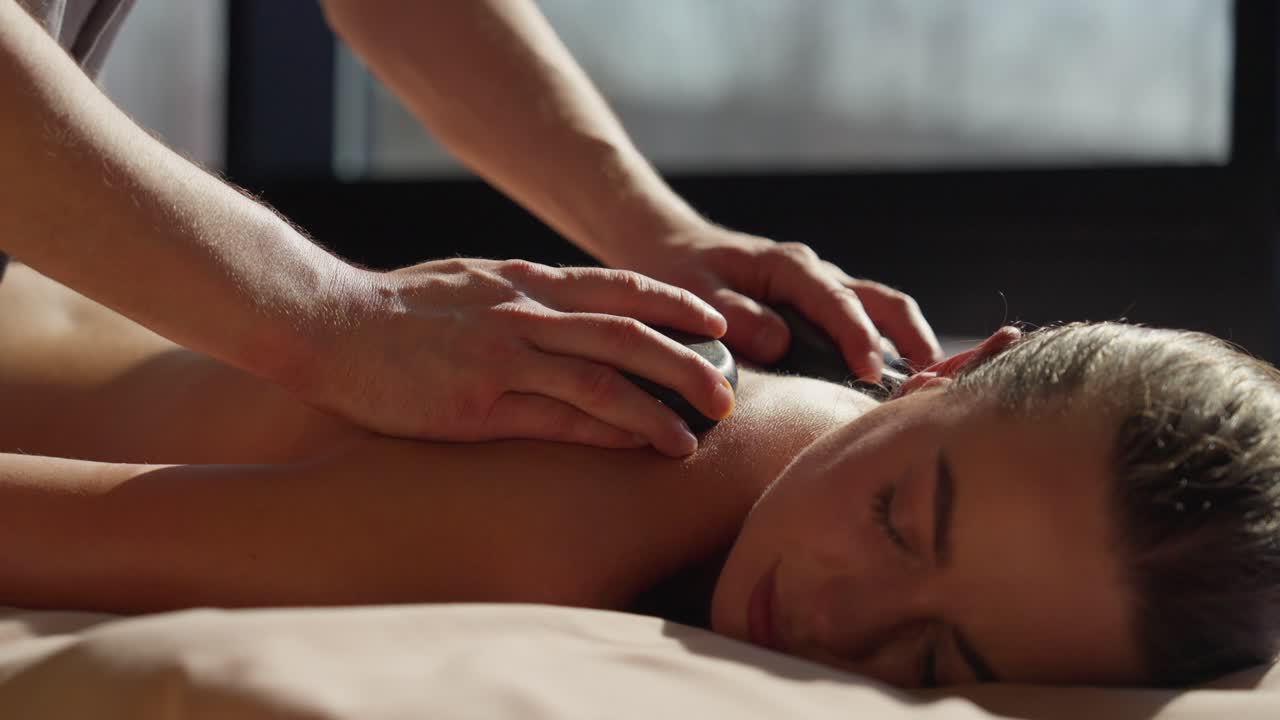 Kvinde, der modtager afslappende varmestensmassage i et spa