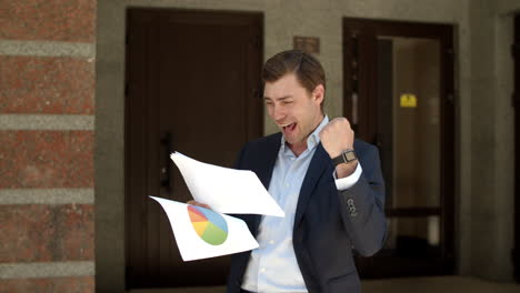 Closeup-businessman-celebrating-at-street.-Man-reading-business-documents