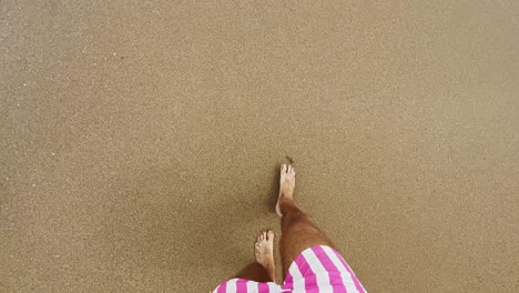 man-walking-on-sea-sand