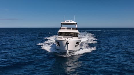 Slow-motion-drone-shot-of-luxury-boat-driving-straight-filmed-from-the-front-side