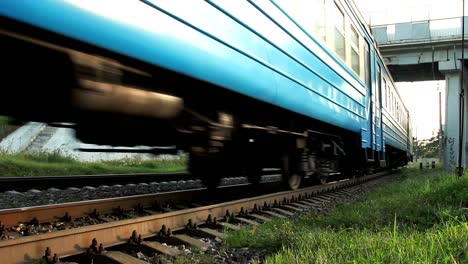 Electric-train-moving-on-railroad.-Passenger-train-moving-under-car-bridge