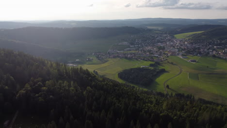 expansive aerial rotate and tilt up shot of the countryside of sainte croix, switzerland on a sunny day.
