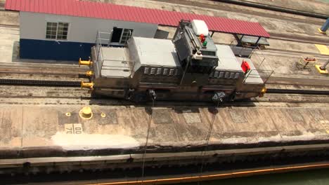 starboard side locomotive slowly pulling the ship at pedro miguel locks, panama canal