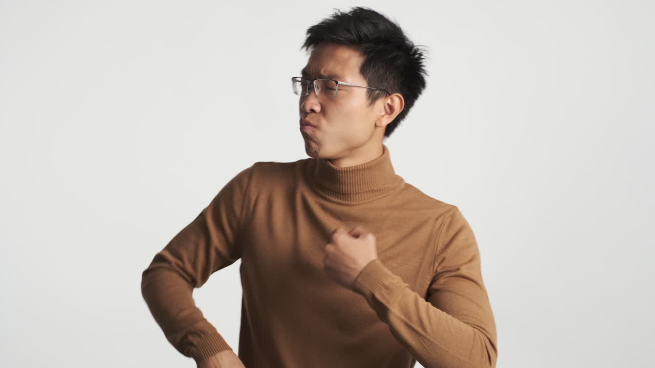 동양인 남자가 눈을 감고 춤을 춘다.