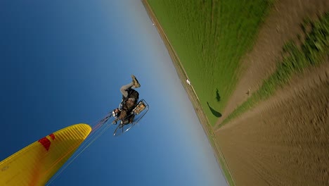 formato vertical: drone fpv zumbos parapente motorizado en el campo agrícola