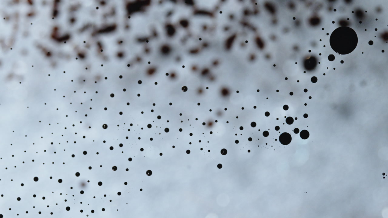 Macro shot of ink mixing, dark droplets in liquid, abstract art