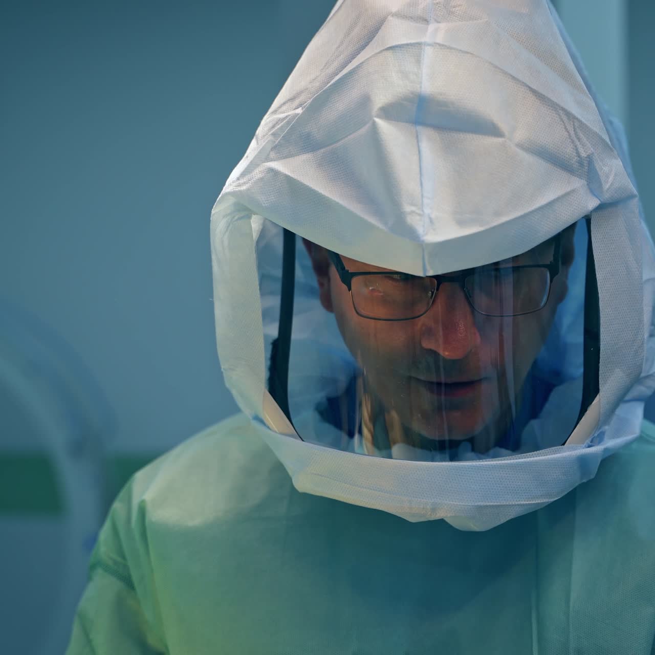 Medico con gli occhiali che indossa una tuta protettiva durante un'operazione. Ritratto di un professionista che lavora in chirurgia traumatologica
