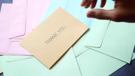 Thank-you-message-and-envelope-on-wooden-table