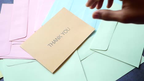 thank you message and envelope on wooden table