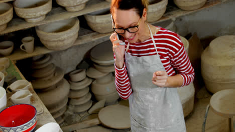 female potter talking on mobile phone 4k