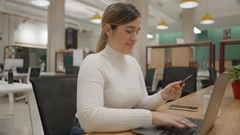 mujer usando portátil y tarjeta de crédito
