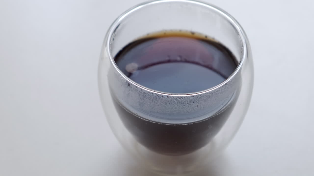 Caffè nero caldo in un bicchiere trasparente a doppia parete