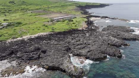 Drone-view-with-a-global-rotating-perspective-of-Pointe-au-Sel-in-Saint-Leu,-Reunion-Island,-showcasing-water,-rocks,-and-the-salt-pans