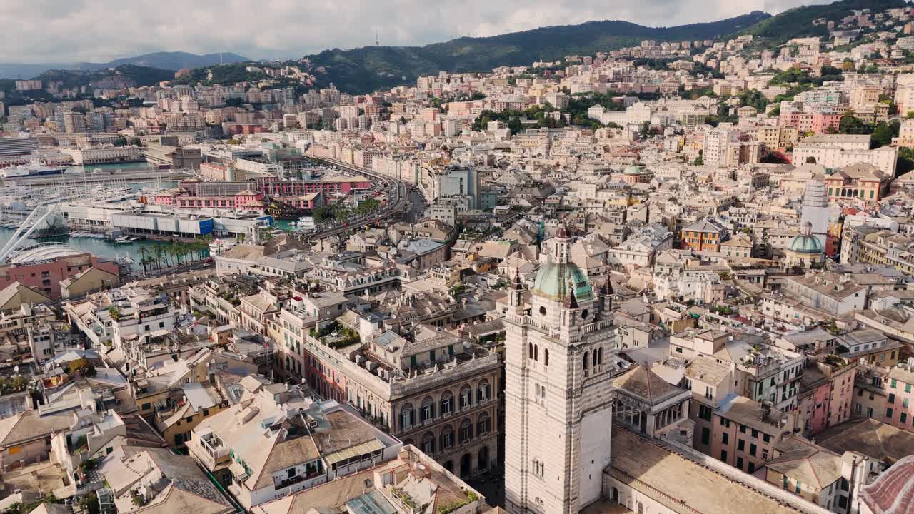 Genoa's historic center and harbor surrounded by hills and coastal buildings, aerial view