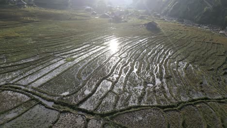 Impresionante-Toma-Aérea-De-Campos-De-Arroz-En-Las-Montañas-Asiáticas-Con-La-Luz-Del-Sol-Reflejada-En-El-Agua