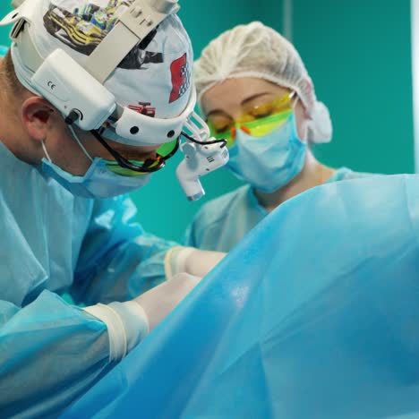 professional doctor perform an operation with assistant. faces in protective masks of medical workers during the surgery process in modern clinic.