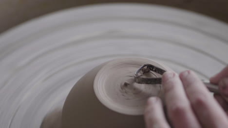 person making pottery on a potters wheel