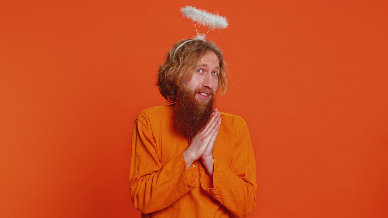 Portrait of smiling shy angelic caucasian man with angel halo nimb over head positive love emotions